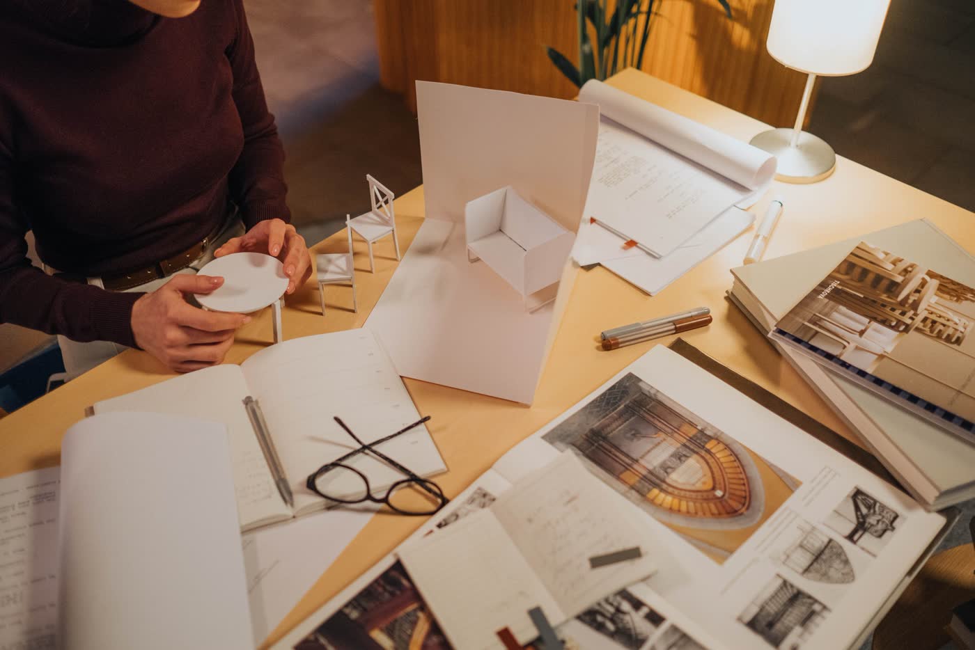 Mesa de trabajo con maqueta, planos y bocetos de un proyecto de arquitectura