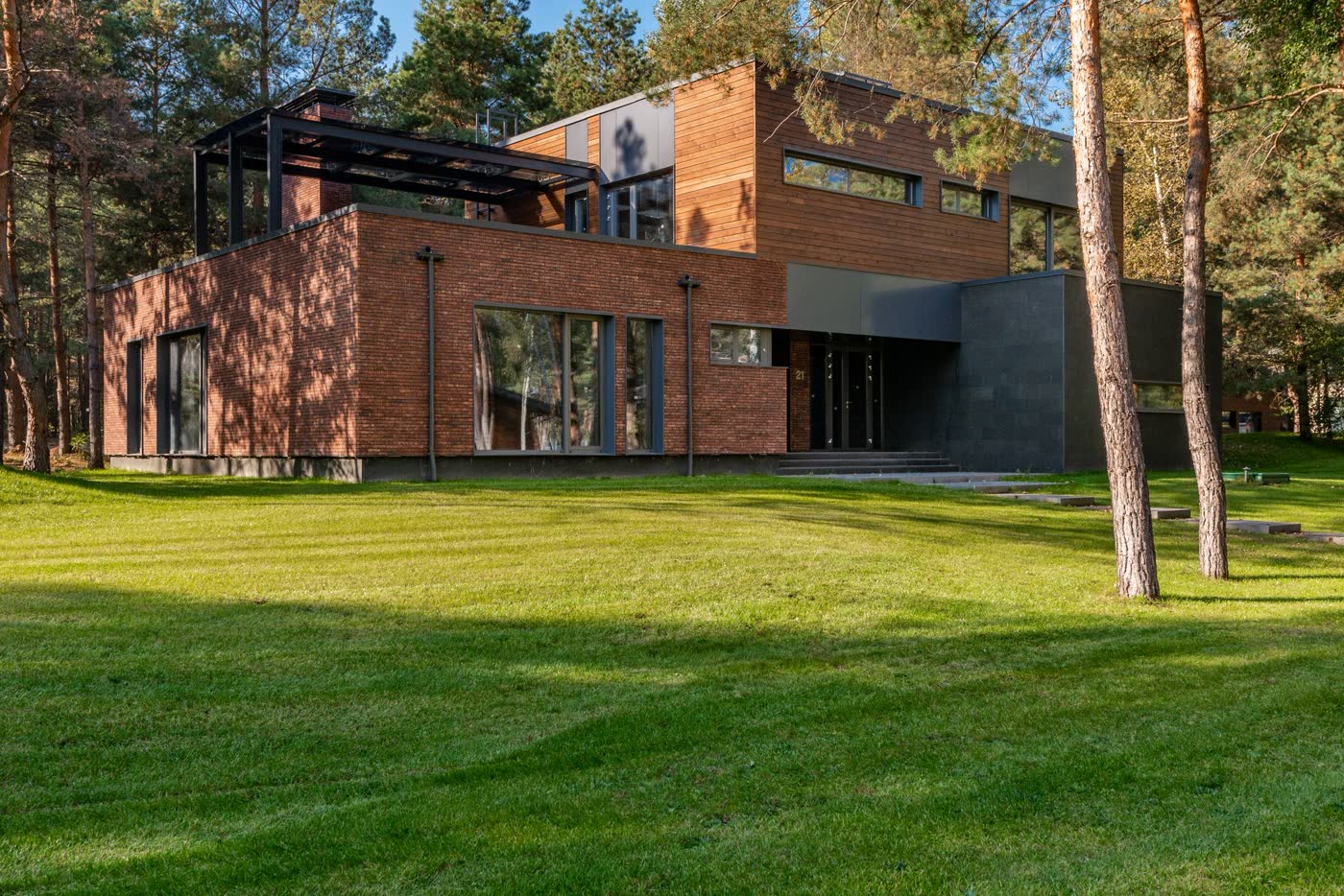 Casa contemporánea de ladrillo y madera entre árboles