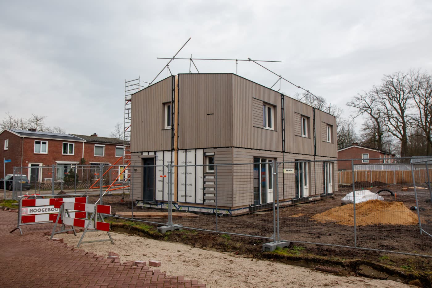 Casa en construcción con andamios y cerco de obra